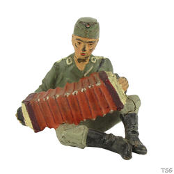 Lineol Soldier sitting, playing an accordion
