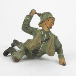 Soldier lying, throwing hand grenade